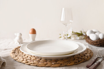 Spring stilish Easter table setting with organic eggs, bunny and blooming flowers.