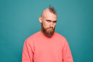 Bearded european man in casual peach isolated on turquoise background with gloomy expression needs support and help