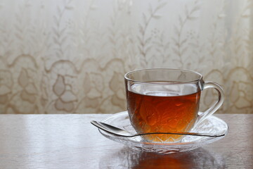 Tea in a transparent cup on a saucer.