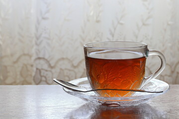Tea in a transparent cup on a saucer.