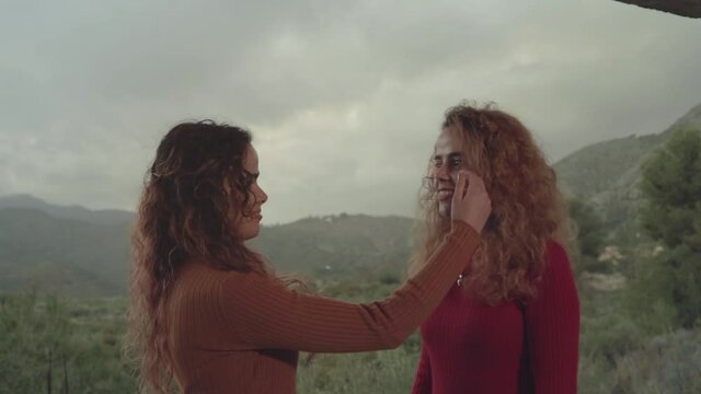 Hermanas gemelas mostrando amistad, felicidad y complicidad en un d&iacute;a nublado
