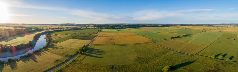 Beautiful aerial panorama of green agricultural fields at sunset in Australia.