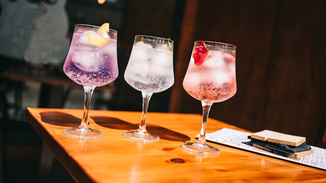 Beautiful line of multi-colored alcoholic cocktails at a party on the martini table, vodka in large glasses
