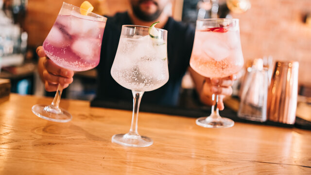 Beautiful line of multi-colored alcoholic cocktails at a party, on the bar martini, vodka in large glasses
