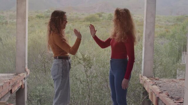 Hermanas gemelas jugando con las manos mostrando amistad, felicidad y complicidad en un d&iacute;a nublado