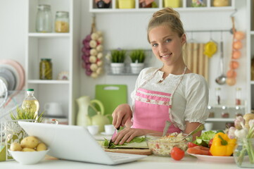 cute girl making salad  on kitchen