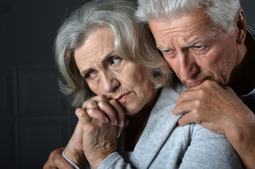 Portrait of sad senior couple posing at home