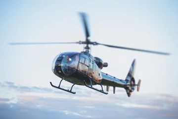 Foto op Plexiglas Civiele zwarte helikopter maakt zich klaar om te vliegen, commerciële charter privéhelikopter op helikopterplatform met mensen aan boord, piloot, krijgt een pilootcursuslicentieconcept, helikopter die op groen gras landt © tsuguliev