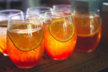 Row line of red colored negroni and spritz aperitif alcohol cocktails on a party of alcohol setting on catering banquet table, vodka, and others on decorated catering table event with bartender