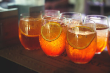 Row line of red colored negroni and spritz aperitif alcohol cocktails on a party of alcohol setting on catering banquet table, vodka, and others on decorated catering table event with bartender
