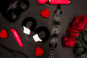 Set of adult toys on a dark background with red roses