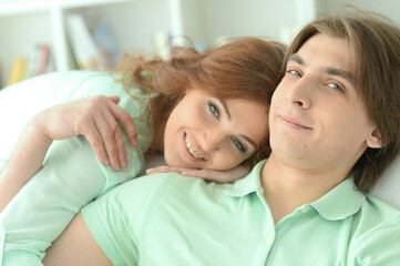 Close up portrait of happy young couple hugging at home