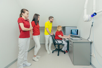 Medical dentist team in dental office discuss and examining x-ray image. looking at computer Desktop screen in modern dental clinic x-ray room In Hospital