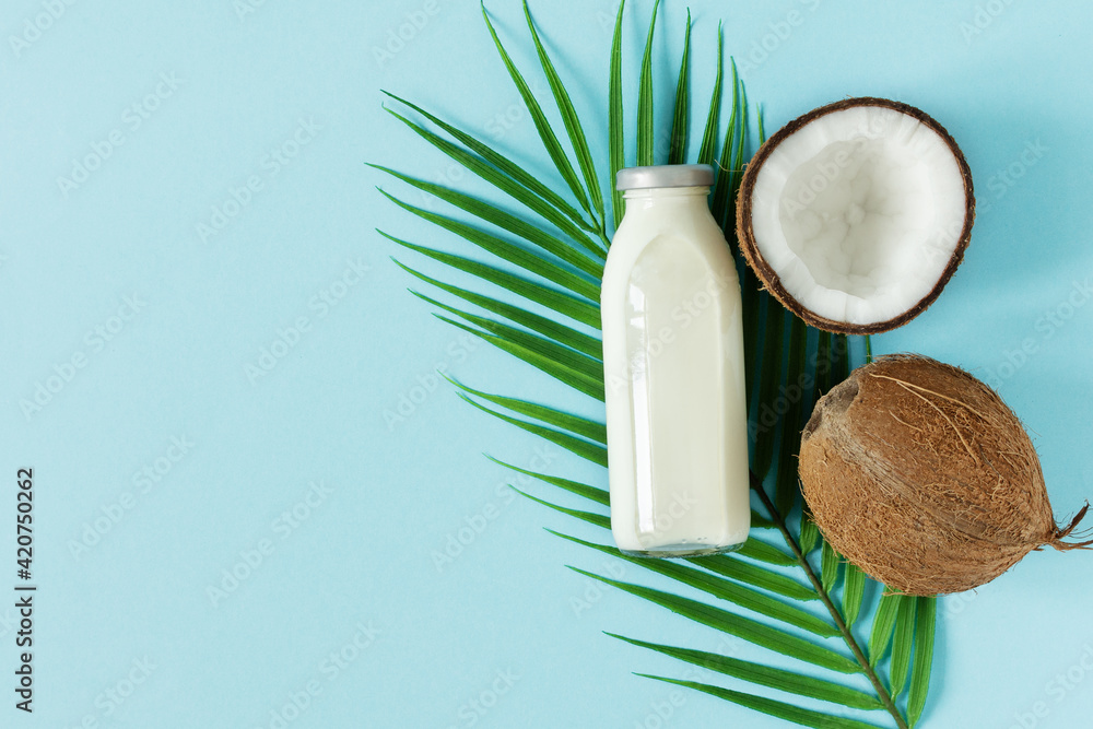 Wall mural Coconut vegan milk top view on blue background.