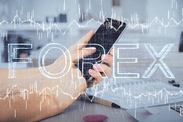 Double exposure of man's hands holding and using a digital device and forex graph drawing. Financial market concept.