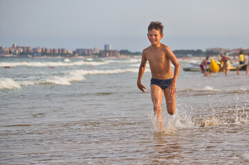 child swims in the sea waves on the beach
