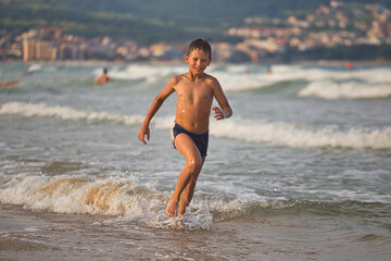 child swims in the sea waves on the beach