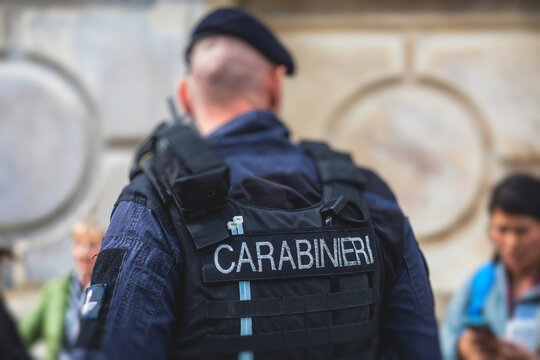 Italian Carabinieri, national gendarmerie of Italy squad,  of Italy patrol formation back view with "Carabiners" logo emblem on uniform maintain public order in the streets of Florence, Tuscany, Italy