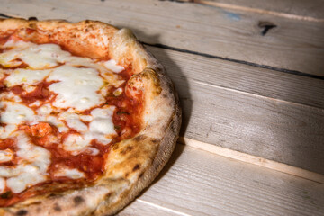Pizza tonda al pomodoro sopra un tavolo di legno