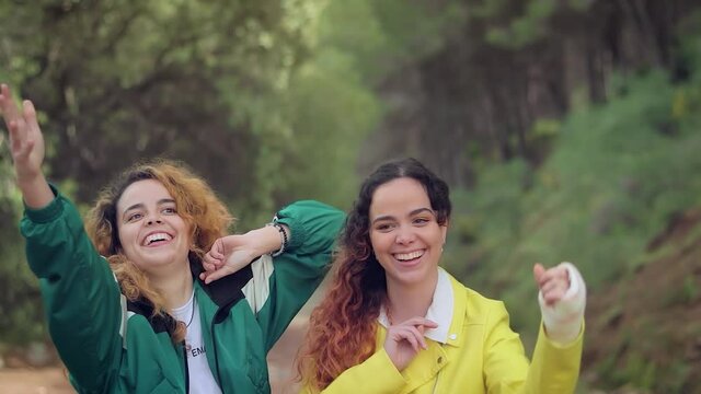 Dos hermanas gemelas lanzan las mascarillas al aire riendo en el bosque 