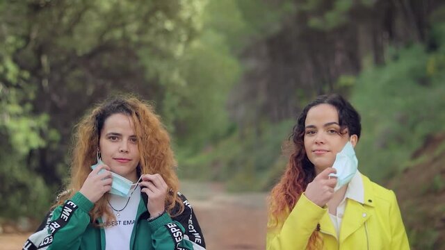 Dos hermanas gemelas se quitan las mascarillas en el bosque mientras hacen senderismo