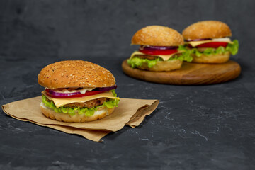 large burger with cutlet, tomato, mayonnaise, lettuce, onion rings. fast food, american food 