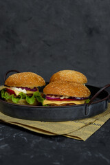 large burger with cutlet, tomato, mayonnaise, lettuce, onion rings. fast food, american food 