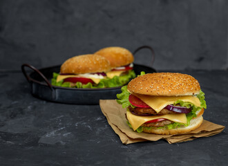 large burger with cutlet, tomato, mayonnaise, lettuce, onion rings. fast food, american food 