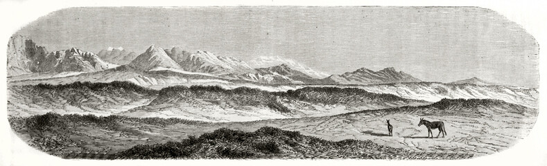 Fototapeta na wymiar Huge horizontal rocky landscape walked by two little mules with mountains far in the distance in Gartok, Tibet. Ancient grey tone etching style art by De Bar, Le Tour du Monde, 1862