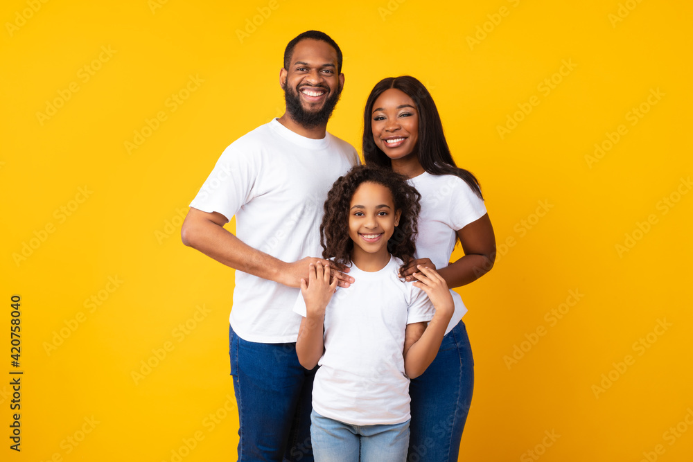 Wall mural african american man hugging his wife and smiling daughter