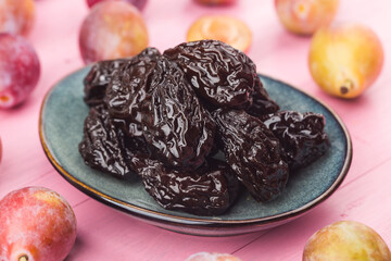 Fresh  prune and dried  prune on wooden board background