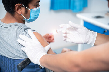A close-up of a doctor vaccinating a patient's shoulder, influenza vaccination in the coronavirus arm, COVID-19 for vaccination.
