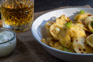 Pelmeni dumplings making process: Cooked pelmeni stuffed with meat in a bowl with seasoning, onions and sour cream. Gluten free recipe for traditional Russian cuisine. handmade ravioli or dumplings.