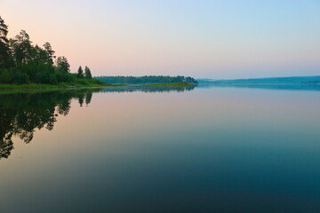 Early morning, calm water surface, fog over the lake. Summer landscape. Argazinskoe reservoir, Chelyabinsk, Russia