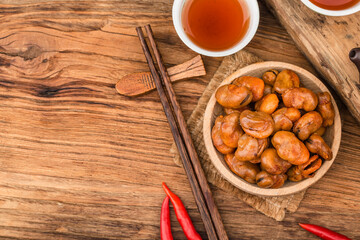 A plate of broad beans placed on a wooden board background