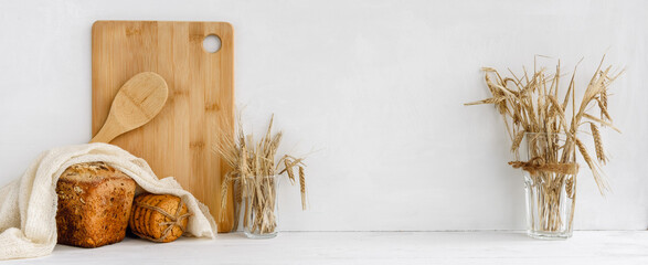 Trendy Kitchen Banner - homemade bread and wooden utensils on a white table. Stock banner and copy...