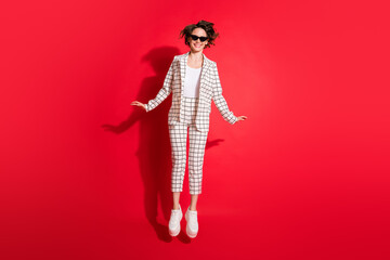 Full body photo of young attractive woman happy smile have fun enjoy jump up isolated over red color background
