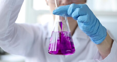 Scientist dripping pink liquid into chemical flask 4k movie