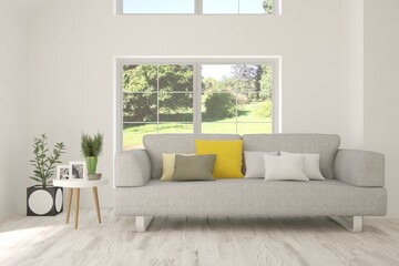 White living room with sofa and summer landscape in window. Scandinavian interior design. 3D illustration