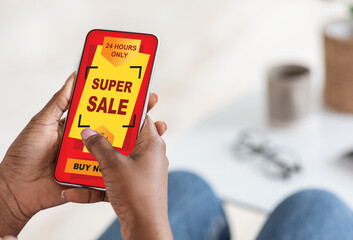 Black woman using shopping application on smartphone, super sale concept