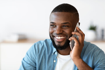 Pleasant Call. Positive Millennial Black Man Talking On Mobile Phone And Smiling