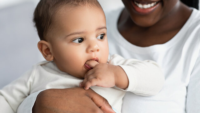 African American Mom Hugging Her Cute Kid At Home