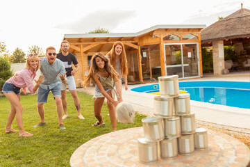 Friends playing knock down tin cans game