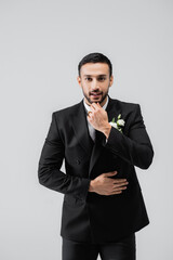 Smiling arabian groom looking at camera isolated on grey