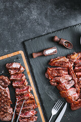 two steaks striploin and t-bon, medium rare, on a stone background. dinner concept for two