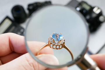 jeweler looking at ring with blue stone, jewerly inspect and verify, pawnshop concept, jewerly shop