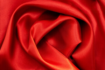 Sleek elegant flowing fabric, laid out in the shape of a rose flower. Silk satin with random pleats. Close-up, selective focus, abstract background