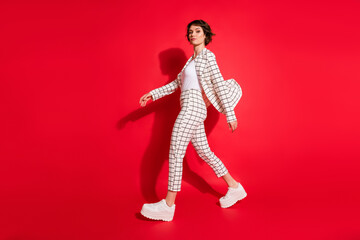 Full body profile side photo of young attractive business woman go walk confident isolated over red color background