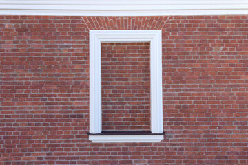 A window in an old brick house, bricked up with brickwork.