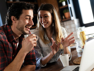 Loving couple drinking coffe in the kitchen. Happy smiling wife enjoy in the morning with her husband.